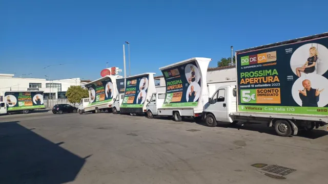 Flotta di camion vela con cartelloni pubblicitari in sosta, campagna a Napoli